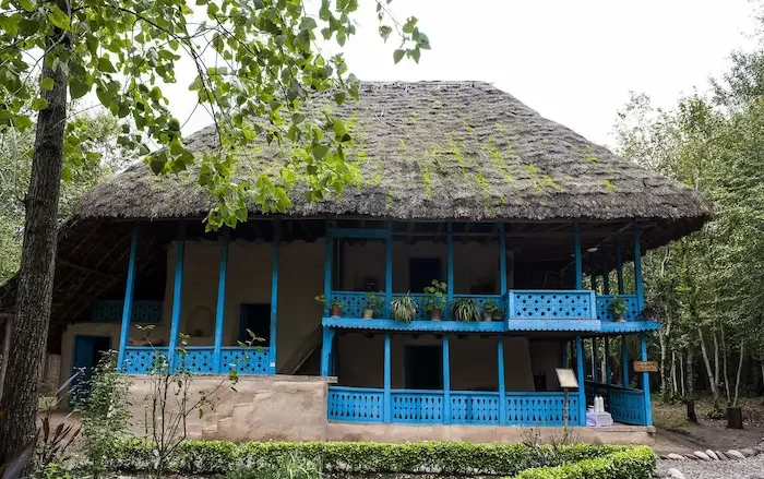 نمایی از موزه تاریخی میراث روستایی گیلان با نرده های چوبی و قدیمی آبی رنگ 665778990