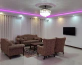 اتاق پذیرایی با مبلمان قهوه ای رنگ و کفپوش سرامیکی و تلوزیون دیواری ویلا در رشت 45649
