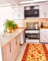 آشپزخانه با کابینت های چوبی، یخچال، هود و گل های خانه ویلایی در لاهیجان 4588654