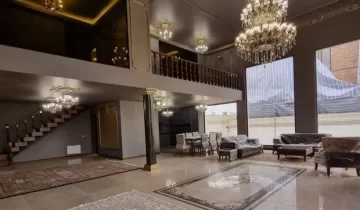 مبلمان کرمی رنگ و سه فرش کرمی رنگ و لوستر کلاسیک سالن نشیمن ویلا در بندر انزلی